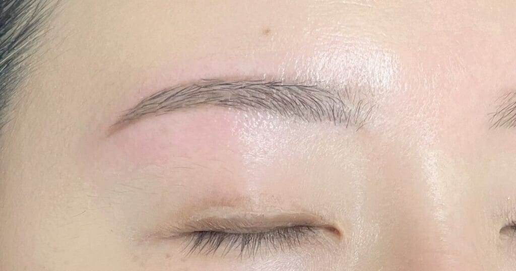 目を閉じた目元のアップ。自眉を活かして細めのアーチに整えた眉
